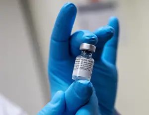 Lcgr2021: Pfizer-BioNTech COVID-19 vaccine vial is held