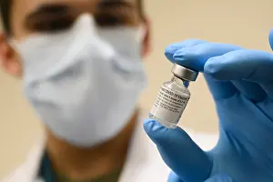 Lcgr2021: Pfizer-BioNTech COVID-19 vaccine vial is held