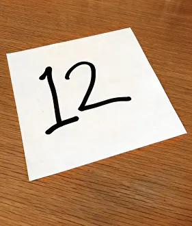 Numerical: Piece of paper on a desk with a large number 12