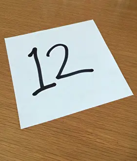 Font: Piece of paper on a desk with a large number 12