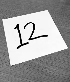 Font: Piece of paper on a desk with a large number 12