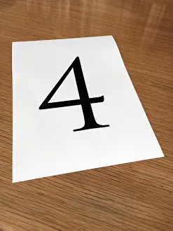 Numerical: Piece of paper on a desk with a large number 4