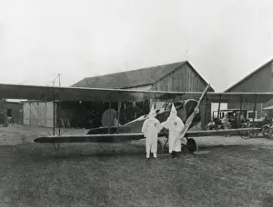 Bi Plane: Two pilots in Ku Klux Klan shrouds pose with their