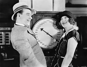 Silliness: Playful couple standing on scale