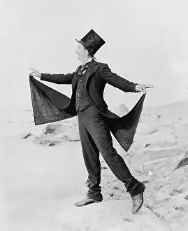 Eccentrics: Playful man formally dressed on beach