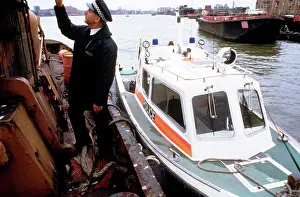 Patrolling: Policeman investigating a river barge