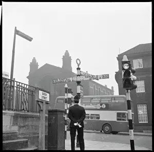 Deste: A policeman standing beside a signpost at the