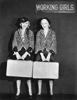 Capes: Portrait of two air hostess holding suitcases and smiling