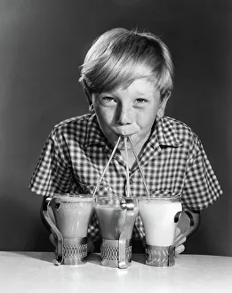 Suck: Portrait of blonde boy drinking with straws from