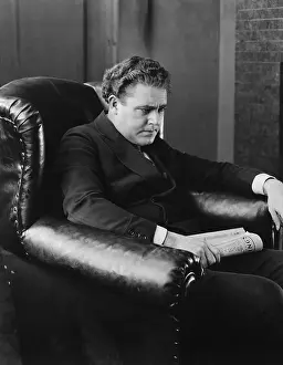 Pensiveness: Portrait of brooding man in easy chair