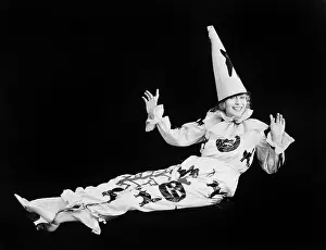 Witty: Portrait of a clown smiling with her arms raised