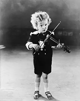Frown: Portrait of little boy playing violin