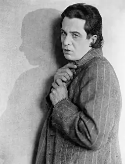 Disturbing: Portrait of man holding coat closed