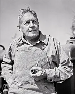 Hickory: Portrait Middle-Aged Farmer Outdoors Leaning on Tractor