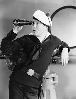 Nonchalant: Portrait of sailor looking through binoculars