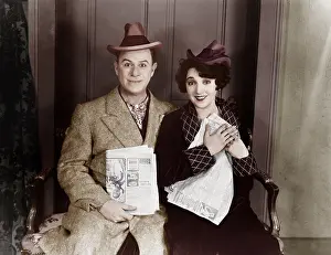 Excite: Portrait of smiling couple with newspapers