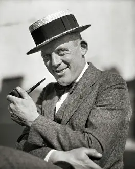 Skimmer: Portrait Smiling Man Smoking a Pipe Wearing a
