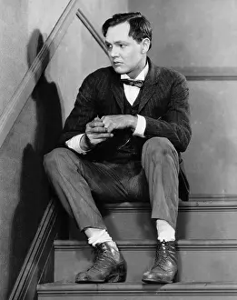Frown: Portrait of troubled man sitting on stairs