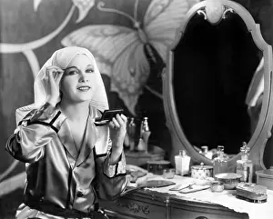 Eyebrow: Portrait of woman applying makeup at dressing table