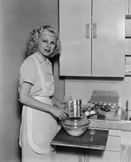 Recipes: Portrait of woman cooking in kitchen