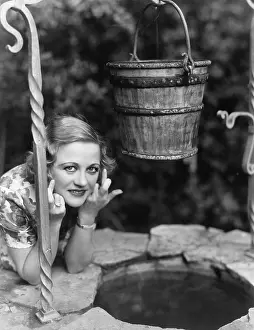 Faithfulness: Portrait of a woman leaning on a well with her finger