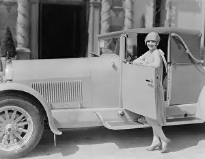 Affluence: Portrait of woman posing with car