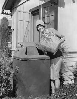 Emptying: Portrait of woman taking out trash