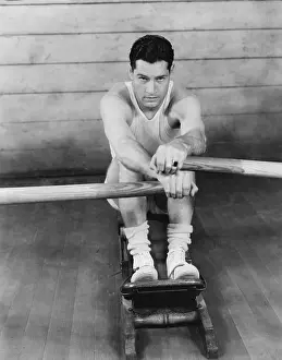 Vigorous: Portrait of a young man exercising on a rowing machine