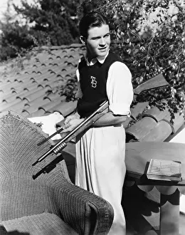 Maintaining: Portrait of young man outside with gun