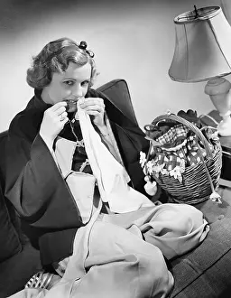 Tags: Portrait of a young woman cutting thread with her teeth
