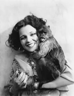Waist Up: Portrait of a young woman hugging her monkey