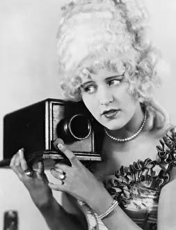 Ruffled: Portrait of a young woman using a camera