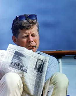 Hyannisport: President John Kennedy smoking a cigar while reading
