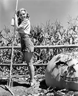 Tiptoes: Pretty farmer with her jack-o'-lantern