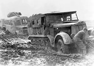 Towing: A prime mover, towing a bus, is stranded in the mud