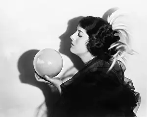 Meditating: Profile of dramatic woman holding sphere