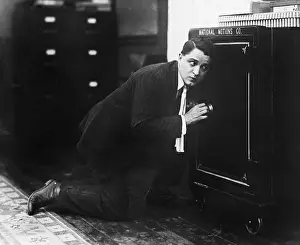 Concentrate: Profile of a man opening the door of a safe