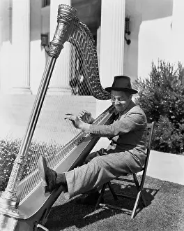 Harpist: Profile of a man playing a harp and smiling