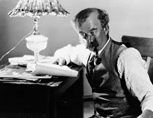 Mustaches: Profile of a man sitting at a desk and holding a