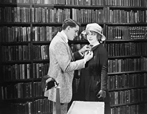 Fasten: Profile of a young man attaching a brooch on a young