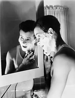 Bathrooms: Profile of a young man in front of a mirror in a