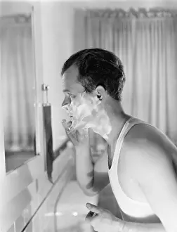 Bathrooms: Profile of a young man in front of a mirror in a