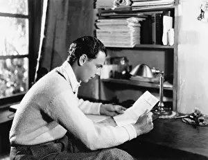 Ponder: Profile of a young man reading a paper at his desk