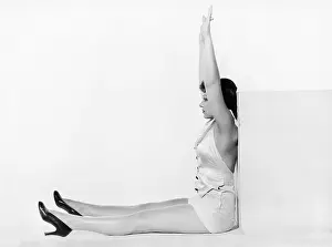 Sandal: Profile of a young woman exercising against a cube