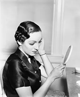 Close Ups: Profile of a young woman looking into a mirror checking
