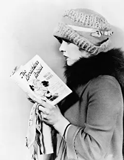 Waist Up: Profile of a young woman reading a book