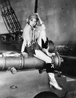 Ponder: Profile of a young woman sitting on a cannon and thinking