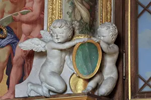 Rosso: Putti holding a medallion in carved stucco from