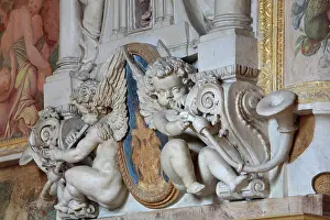 Rosso: Putti playing trumpets in carved stucco, below