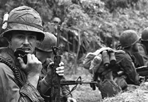Operators: A radio operator armed with an M-16 rifle talks